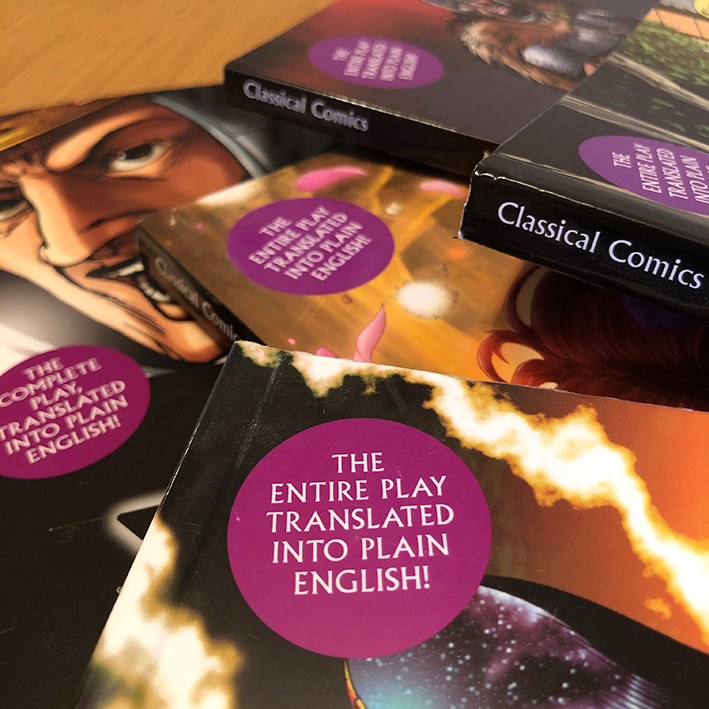 Five Plain Text graphic novels in a pile each with an purple circle. Wording reads: The entire play translated into plain English.
